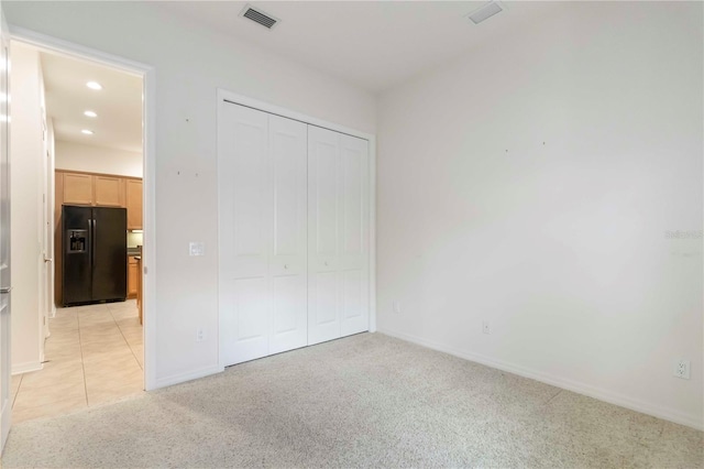 7314 Hamilton Rd, Bradenton, FL 34209 - unfurnished bedroom with black refrigerator with ice dispenser, light colored carpet, a closet, and recessed lighting