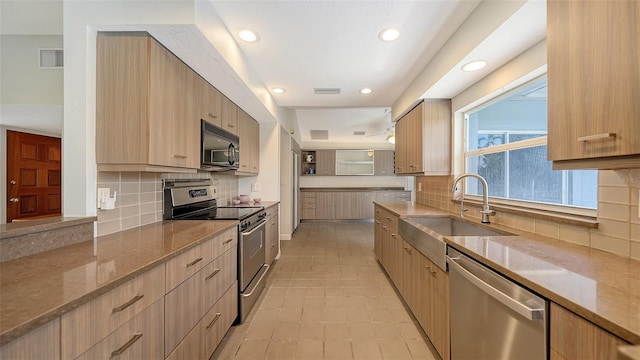 4771 Riverwood Cir, Sarasota, FL 34231 - kitchen with stainless steel appliances, modern cabinets, light stone counters, recessed lighting, and tasteful backsplash