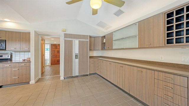 4771 Riverwood Cir, Sarasota, FL 34231 - kitchen featuring appliances with stainless steel finishes, a ceiling fan, vaulted ceiling, light tile patterned floors, and glass insert cabinets