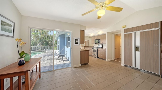 4771 Riverwood Cir, Sarasota, FL 34231 - kitchen featuring stainless steel stove, black microwave, paneled built in refrigerator, a ceiling fan, and vaulted ceiling