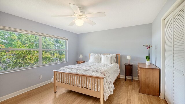 4771 Riverwood Cir, Sarasota, FL 34231 - bedroom featuring light wood-style flooring, a ceiling fan, and a closet