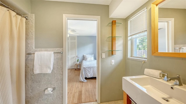 4771 Riverwood Cir, Sarasota, FL 34231 - ensuite bathroom featuring vanity, a shower with curtain, tile walls, and wood finished floors