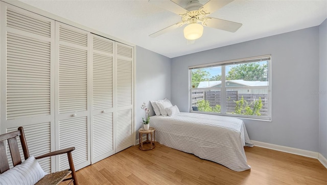 4771 Riverwood Cir, Sarasota, FL 34231 - bedroom with a closet, light wood-style floors, and a ceiling fan