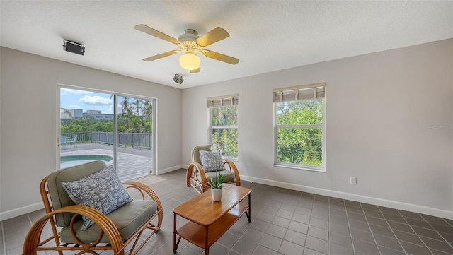 4771 Riverwood Cir, Sarasota, FL 34231 - sitting room with dark tile patterned floors, a ceiling fan, and a textured ceiling