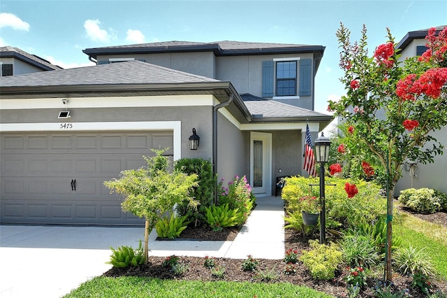 5475 Summit Gln, Bradenton, FL 34203 - view of front of home with stucco siding, a garage, concrete driveway, and a shingled roof