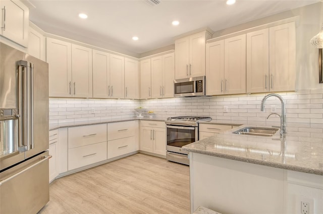 5475 Summit Gln, Bradenton, FL 34203 - kitchen featuring appliances with stainless steel finishes, a sink, light stone counters, recessed lighting, and white cabinetry