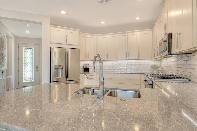 5475 Summit Gln, Bradenton, FL 34203 - kitchen with appliances with stainless steel finishes, a sink, stone counters, white cabinetry, and recessed lighting