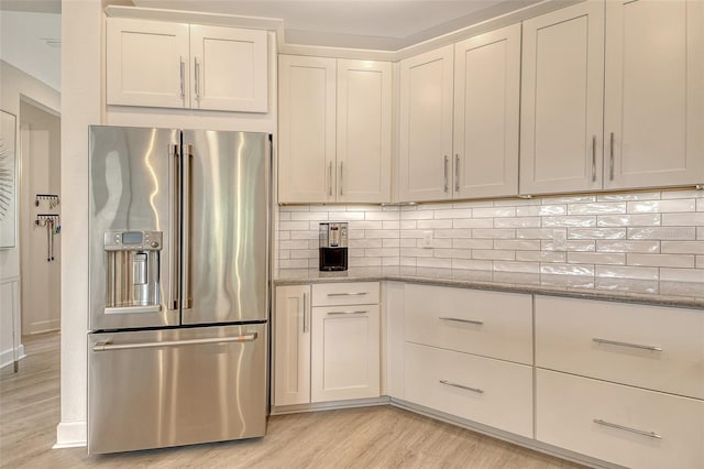 5475 Summit Gln, Bradenton, FL 34203 - kitchen featuring high quality fridge, light wood finished floors, light stone countertops, decorative backsplash, and white cabinets