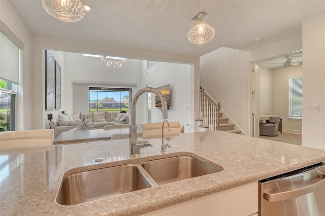 5475 Summit Gln, Bradenton, FL 34203 - kitchen with a sink, dishwasher, light stone counters, open floor plan, and decorative light fixtures
