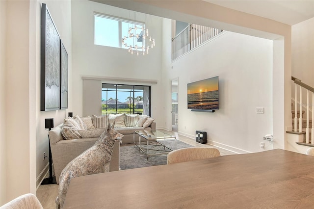 5475 Summit Gln, Bradenton, FL 34203 - living area featuring stairway, healthy amount of natural light, baseboards, a towering ceiling, and a chandelier