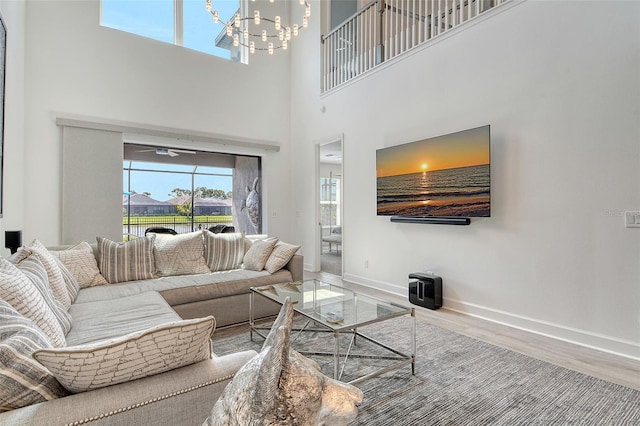 5475 Summit Gln, Bradenton, FL 34203 - living area featuring wood finished floors, a towering ceiling, a chandelier, and baseboards