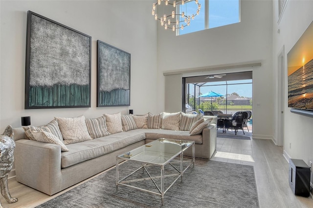 5475 Summit Gln, Bradenton, FL 34203 - living room featuring wood finished floors, a chandelier, a high ceiling, and baseboards
