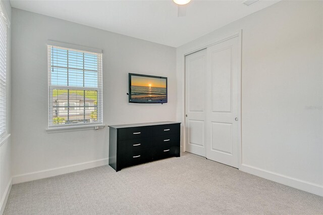 5475 Summit Gln, Bradenton, FL 34203 - unfurnished bedroom featuring light colored carpet, a closet, baseboards, and ceiling fan