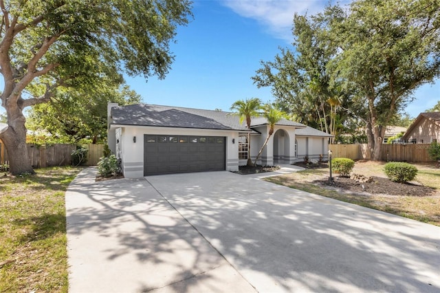 4473 Diamond Cir S, Sarasota, FL 34233 - view of front of house featuring driveway, an attached garage, stucco siding, and a shingled roof