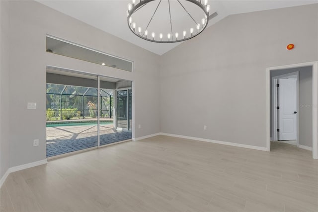 4473 Diamond Cir S, Sarasota, FL 34233 - empty room with a chandelier, high vaulted ceiling, baseboards, and light wood-type flooring