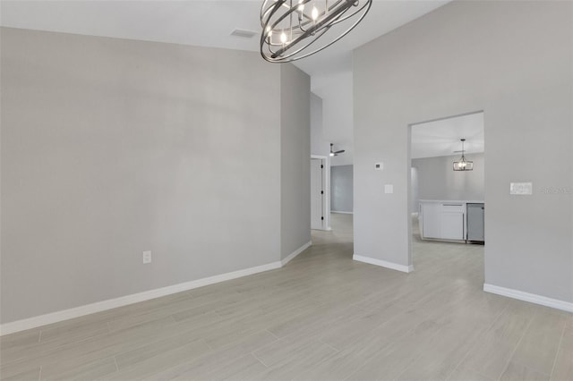 4473 Diamond Cir S, Sarasota, FL 34233 - spare room with a chandelier, high vaulted ceiling, baseboards, and light wood-type flooring