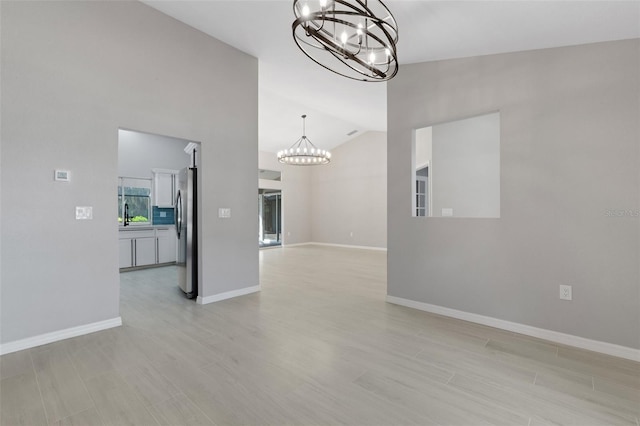4473 Diamond Cir S, Sarasota, FL 34233 - unfurnished living room featuring a chandelier, lofted ceiling, light wood-style flooring, and baseboards