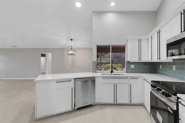4473 Diamond Cir S, Sarasota, FL 34233 - kitchen with appliances with stainless steel finishes, a sink, a peninsula, light countertops, and recessed lighting