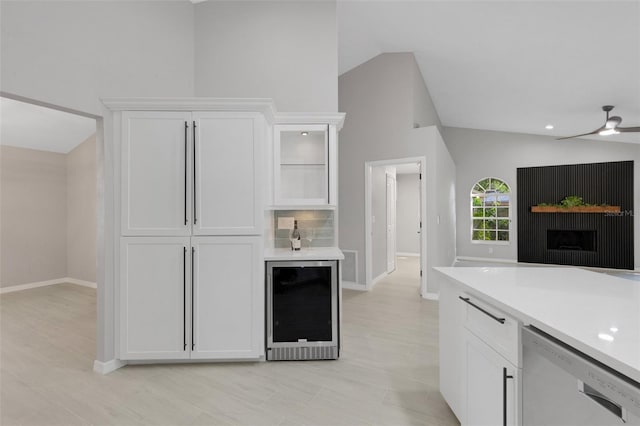 4473 Diamond Cir S, Sarasota, FL 34233 - kitchen with beverage cooler, dishwasher, white cabinets, light countertops, and vaulted ceiling