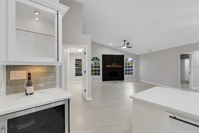 4473 Diamond Cir S, Sarasota, FL 34233 - living room with wine cooler, ceiling fan, lofted ceiling, baseboards, and a fireplace