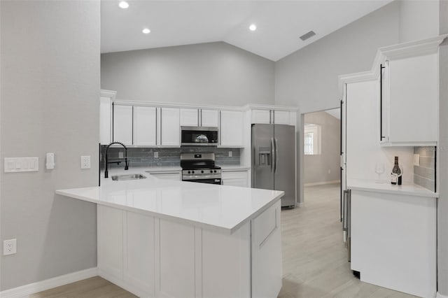 4473 Diamond Cir S, Sarasota, FL 34233 - kitchen featuring stainless steel appliances, a sink, decorative backsplash, a peninsula, and light countertops
