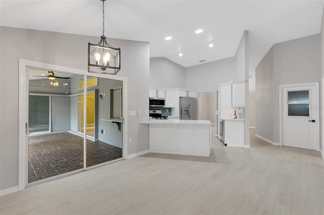 4473 Diamond Cir S, Sarasota, FL 34233 - kitchen with stainless steel appliances, white cabinets, baseboards, and high vaulted ceiling