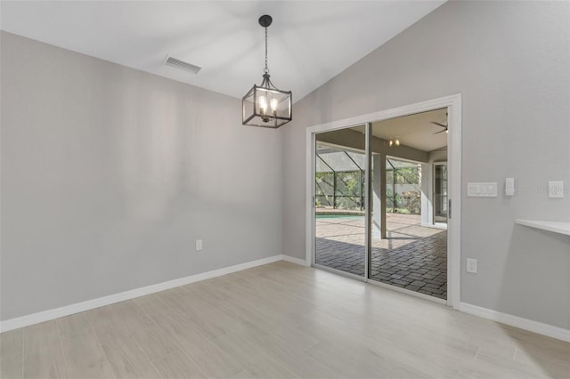 4473 Diamond Cir S, Sarasota, FL 34233 - empty room with lofted ceiling, a chandelier, baseboards, and wood finished floors