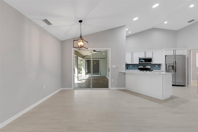4473 Diamond Cir S, Sarasota, FL 34233 - kitchen with stainless steel appliances, white cabinetry, baseboards, ceiling fan, and decorative light fixtures