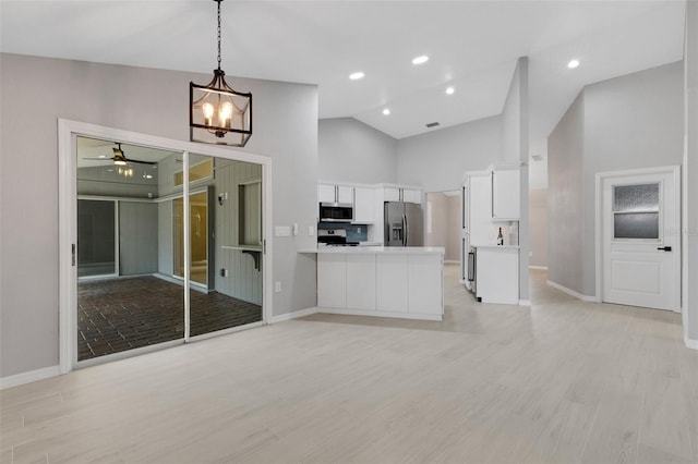 4473 Diamond Cir S, Sarasota, FL 34233 - kitchen featuring stainless steel appliances, white cabinets, baseboards, a peninsula, and high vaulted ceiling