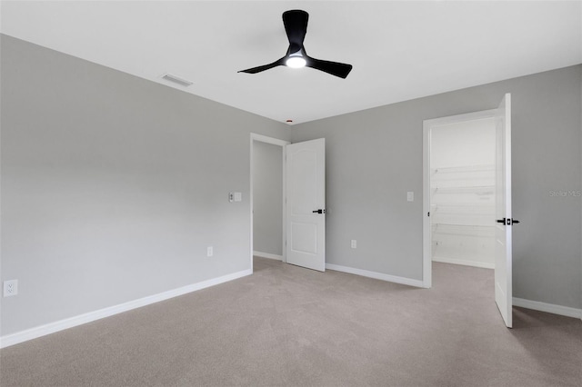 4473 Diamond Cir S, Sarasota, FL 34233 - unfurnished bedroom with a walk in closet, baseboards, light carpet, ceiling fan, and a closet