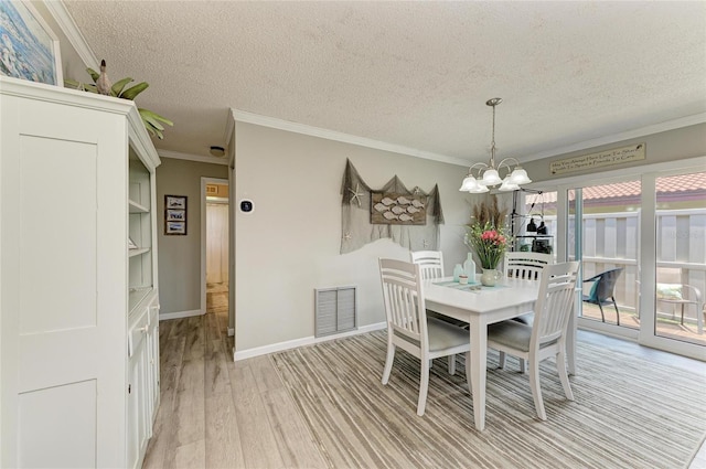 3213 Mercer Rd, Bradenton, FL 34207 - dining area featuring a chandelier, ornamental molding, light wood-style floors, a textured ceiling, and baseboards