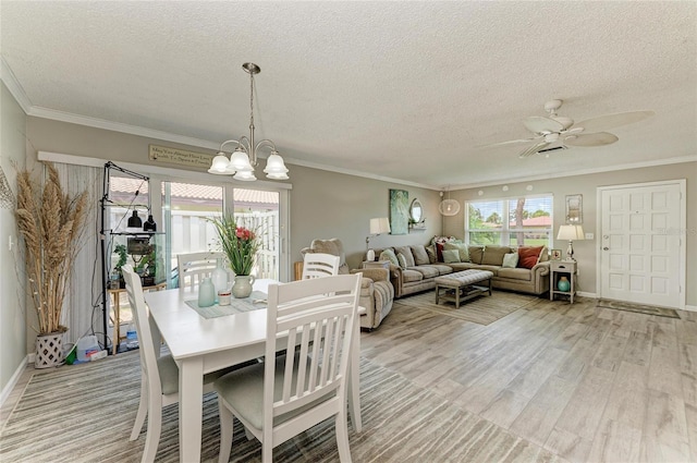 3213 Mercer Rd, Bradenton, FL 34207 - dining room featuring a ceiling fan, a chandelier, a textured ceiling, crown molding, and light wood-style floors
