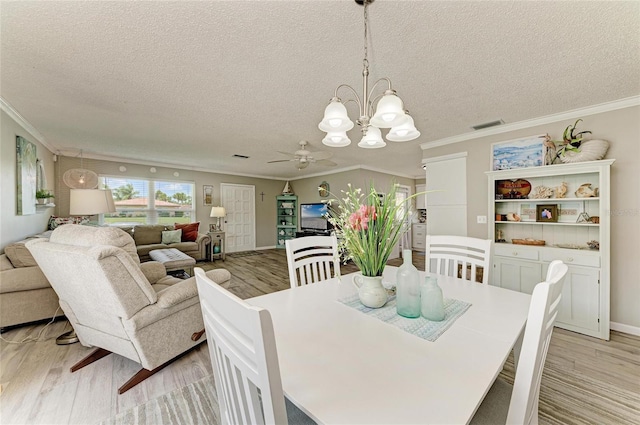 3213 Mercer Rd, Bradenton, FL 34207 - dining room with light wood-style flooring, crown molding, a chandelier, a ceiling fan, and a textured ceiling