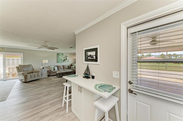 3213 Mercer Rd, Bradenton, FL 34207 - kitchen with a textured ceiling, a breakfast bar, healthy amount of natural light, crown molding, and ceiling fan