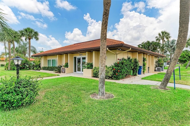 3213 Mercer Rd, Bradenton, FL 34207 - back of property with french doors, a lawn, a tile roof, and stucco siding