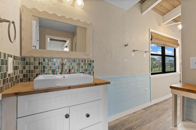 6406 Lincoln Rd, Bradenton, FL 34203 - bathroom with wood finished floors, vanity, decorative backsplash, and beam ceiling