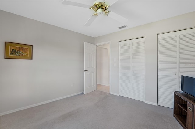 1654 Waxwing Ct, Venice, FL 34293 - unfurnished bedroom with carpet, multiple closets, baseboards, and a ceiling fan