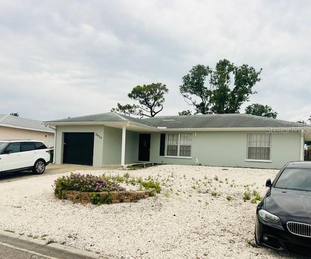8409 43rd Ave W, Bradenton, FL 34209 - ranch-style house with a garage, stucco siding, and driveway