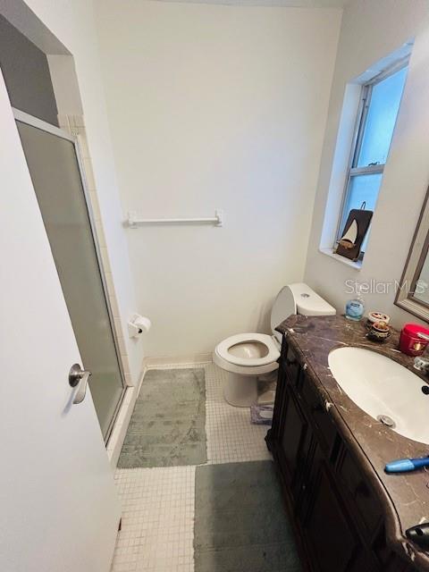8409 43rd Ave W, Bradenton, FL 34209 - full bath featuring a stall shower, vanity, toilet, and tile patterned flooring