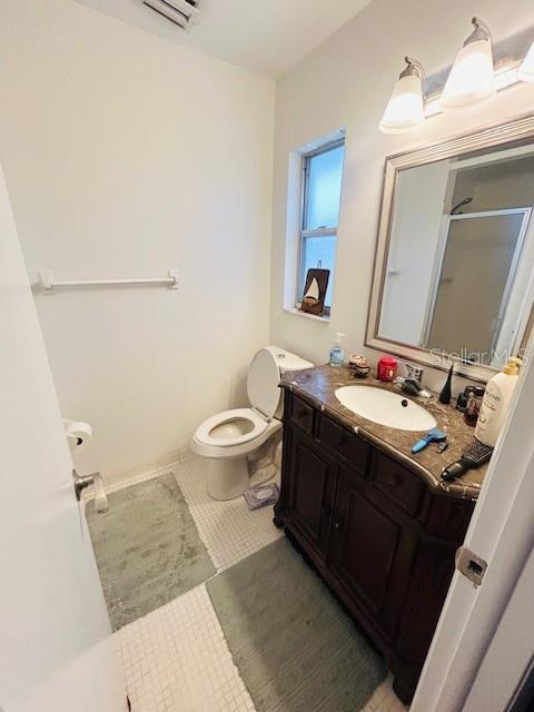 8409 43rd Ave W, Bradenton, FL 34209 - bathroom with a stall shower, toilet, vanity, and tile patterned flooring