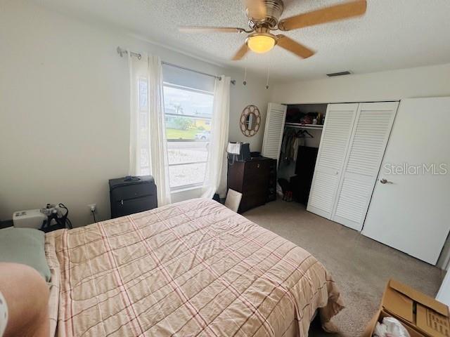 8409 43rd Ave W, Bradenton, FL 34209 - carpeted bedroom with a closet, a textured ceiling, and ceiling fan