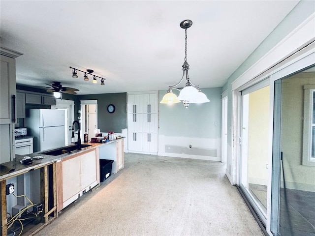 104 Pops Ln, Nokomis, FL 34275 - kitchen featuring freestanding refrigerator, decorative light fixtures, a sink, ceiling fan, and light countertops