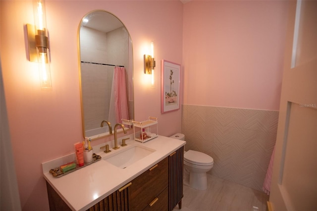 6713 Taneytown St, North Port, FL 34291 - bathroom featuring toilet, vanity, curtained shower, a wainscoted wall, and tile walls