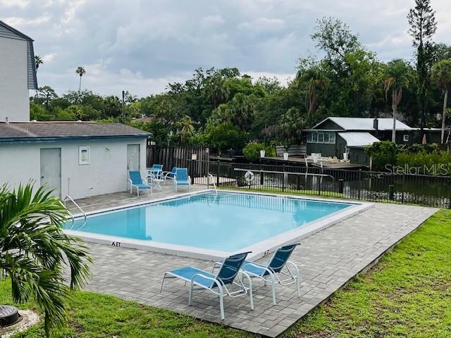 2124 N Tamiami Trl Unit 108, Sarasota, FL 34234 - community pool featuring a patio and view of wooded area
