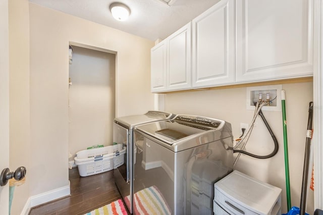 102 28th St W, Bradenton, FL 34205 - washroom with cabinet space, washer and clothes dryer, baseboards, and wood finished floors