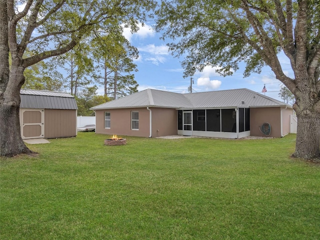 27 Sea Shark Path, Palm Coast, FL 32164 - back of house featuring a sunroom, an outdoor fire pit, a yard, and metal roof