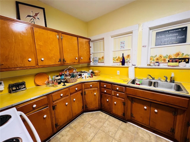 1019 10th Ave W, Bradenton, FL 34205 - kitchen featuring a sink, light tile patterned floors, light countertops, and brown cabinets