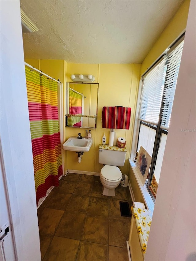 1019 10th Ave W, Bradenton, FL 34205 - full bath with a sink, baseboards, toilet, a textured ceiling, and a shower with shower curtain