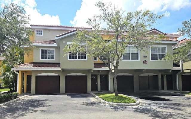 5711 Bentgrass Dr Unit 19-203, Sarasota, FL 34235 - townhome / multi-family property with an attached garage, stucco siding, a tile roof, and driveway
