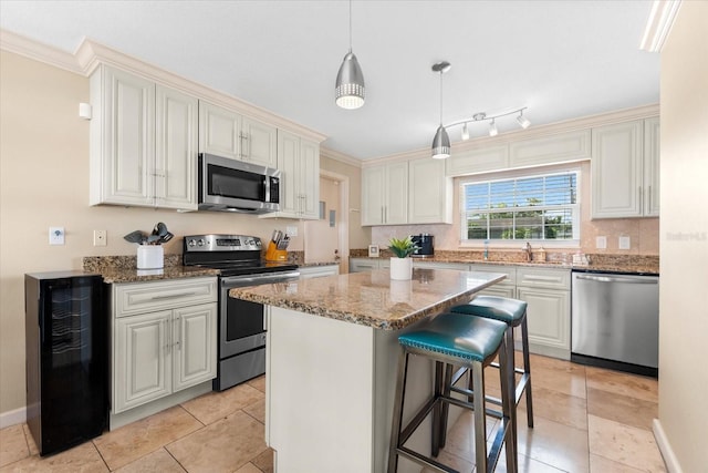 1723 Laramie St, Sarasota, FL 34231 - kitchen with stainless steel appliances, beverage cooler, light stone countertops, a kitchen island, and a kitchen bar